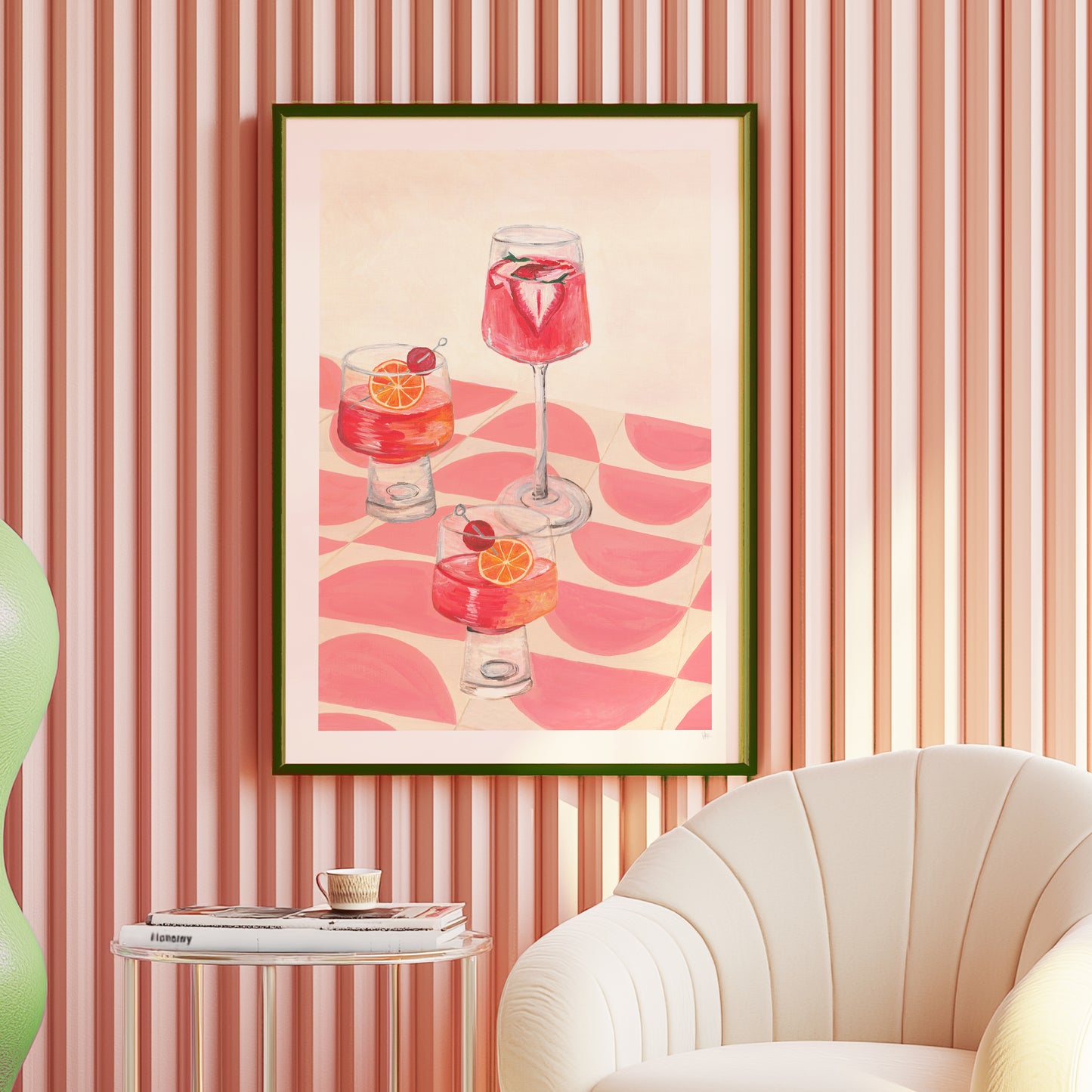 Framed artwork of cocktails on a wall with striped wallpaper and a chair.