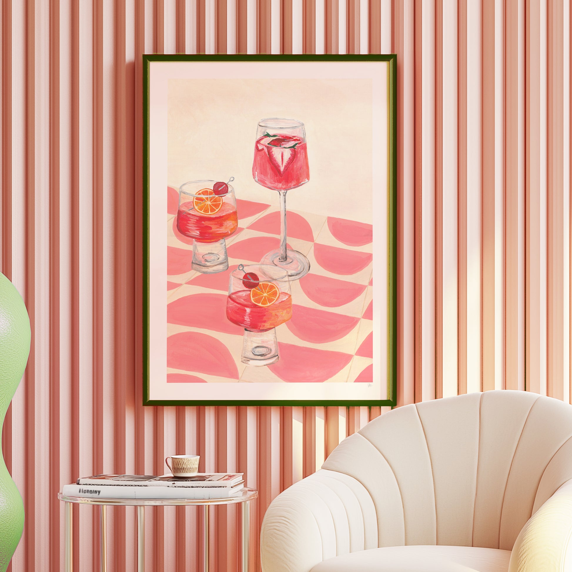 Framed artwork of cocktails on a wall with striped wallpaper and a chair.