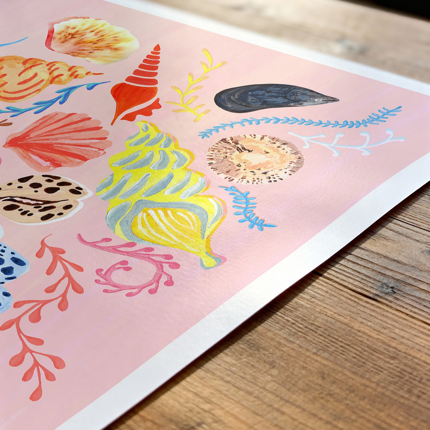 Colorful sea-themed stickers on a pink background, placed on a wooden surface.