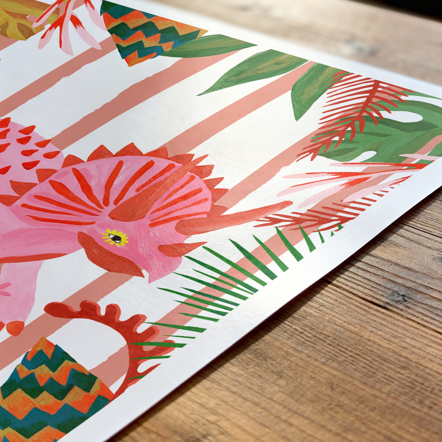 Colorful illustration of a fish and tropical leaves on a wooden surface
