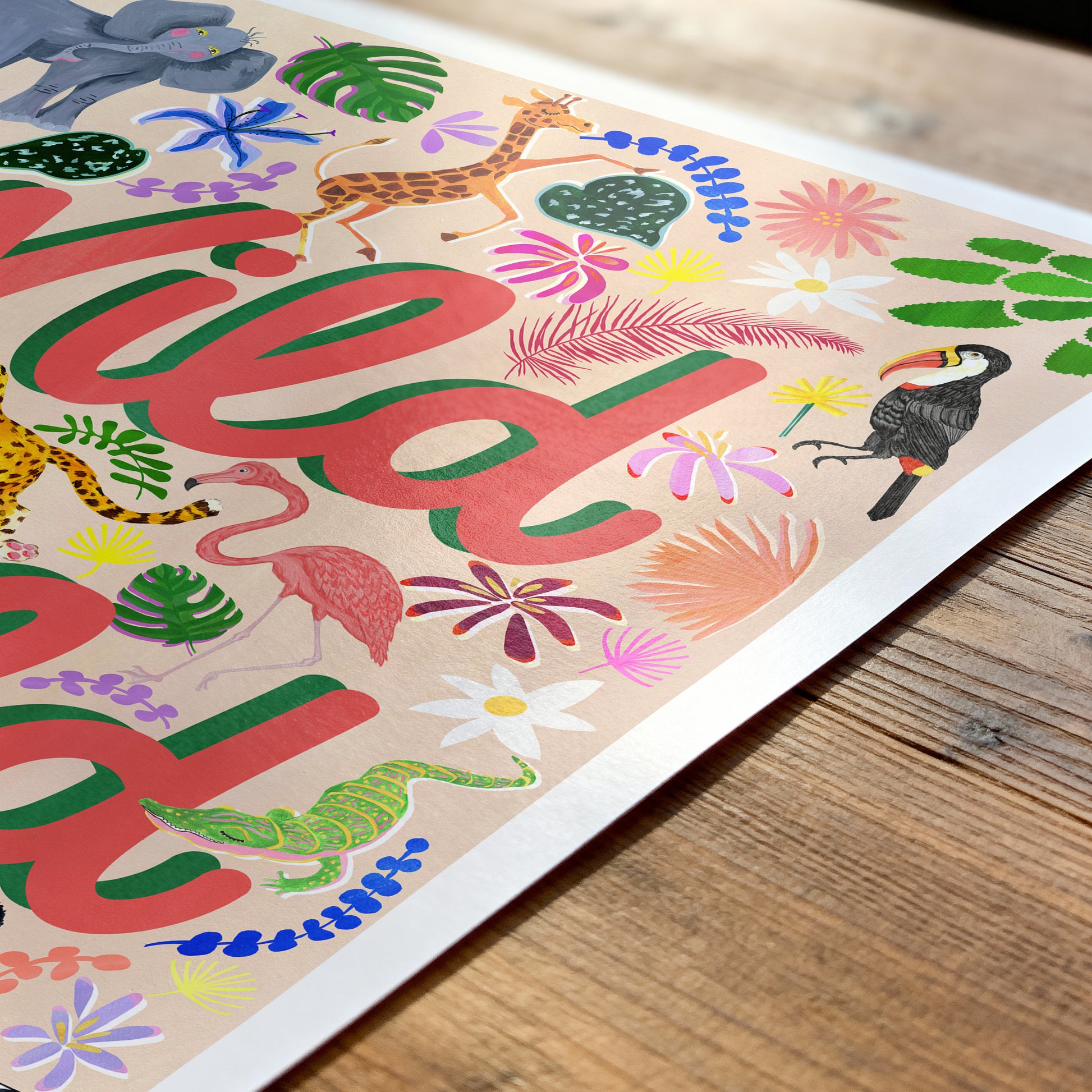 Colorful children's poster with jungle animals and the word 'wild' on a wooden surface.