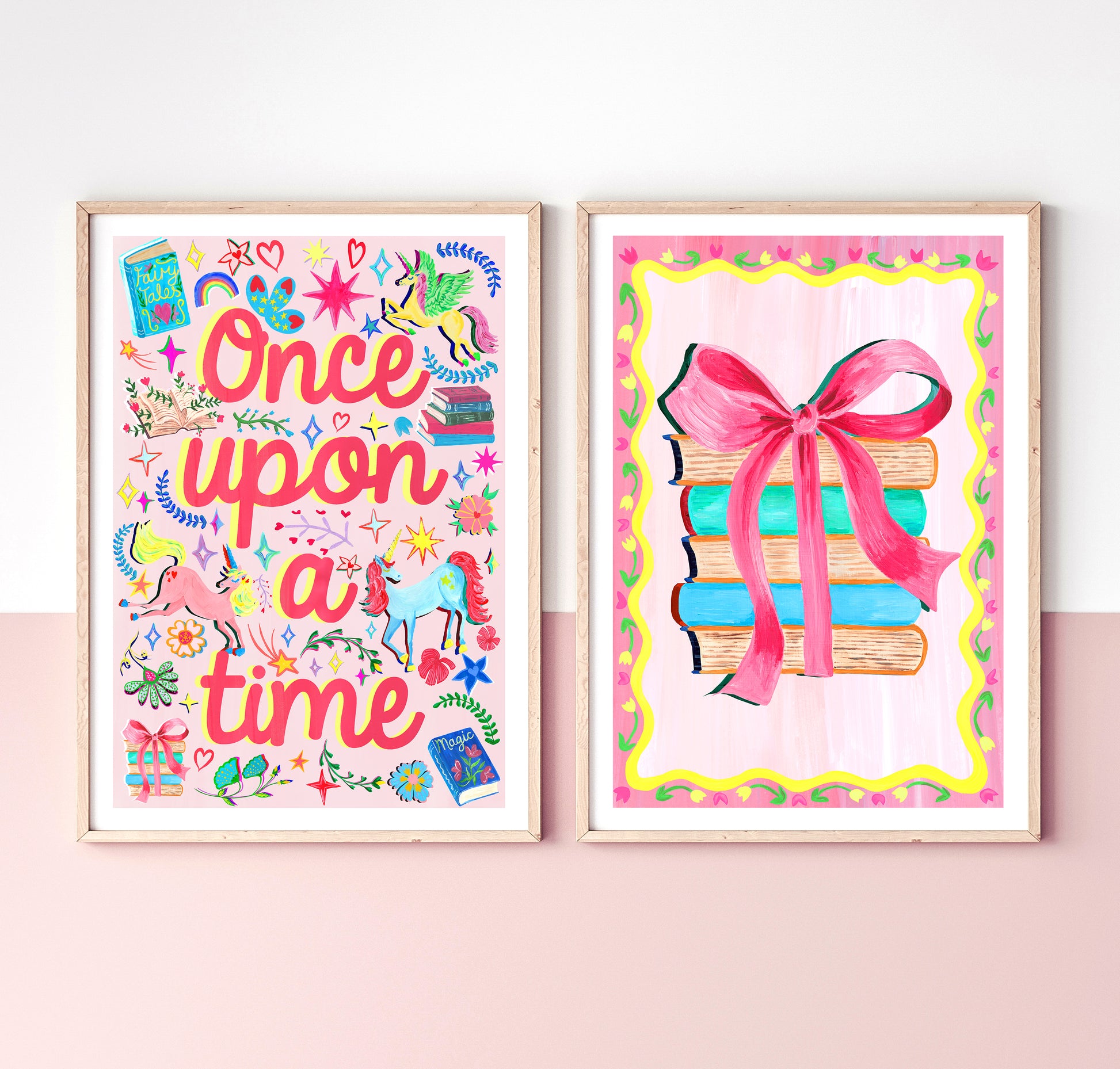Two colorful framed prints on a pink wall, one with 'Once upon a time' text and the other with books and a bow.
