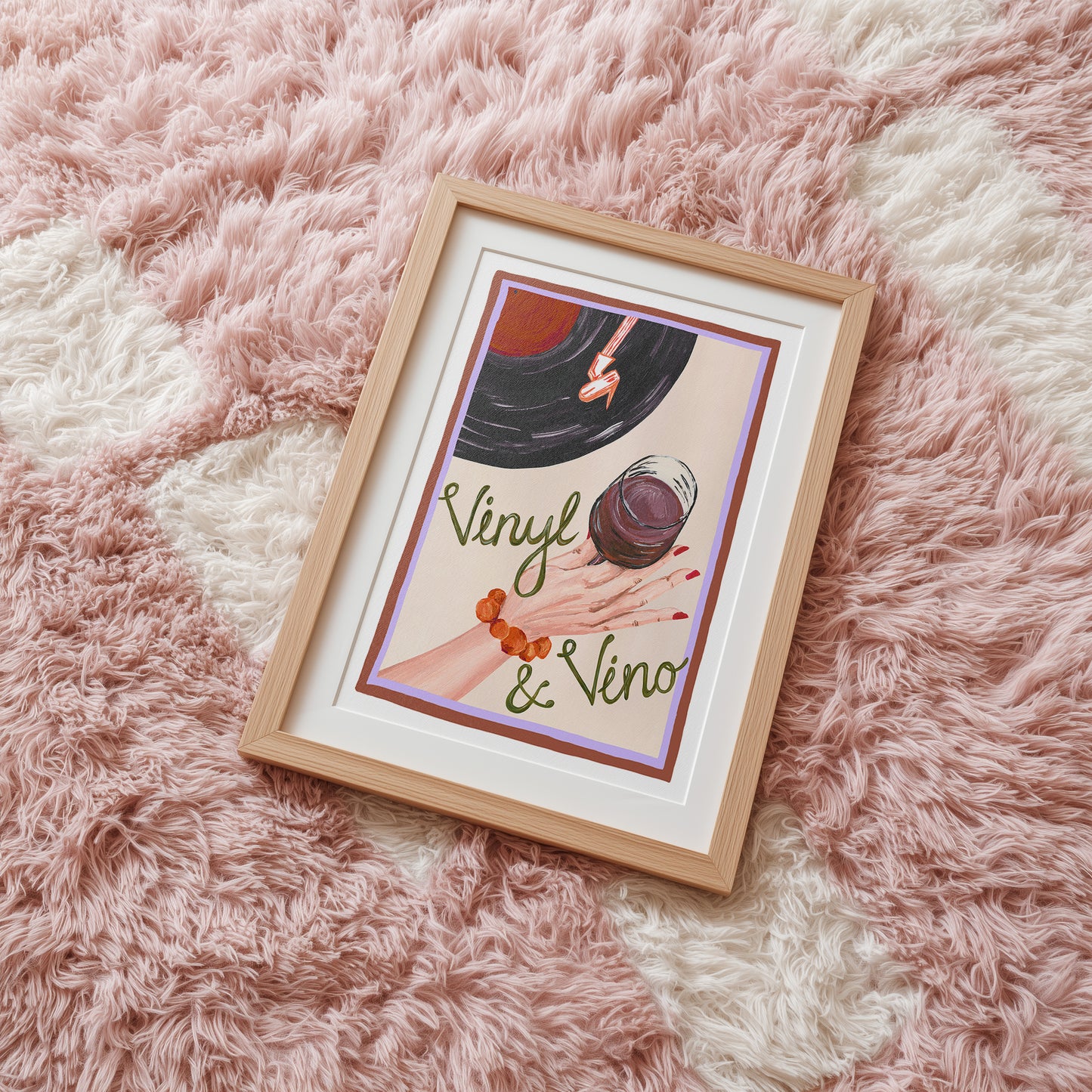 Framed artwork with 'Vinyl & Vino' text on a fluffy pink surface