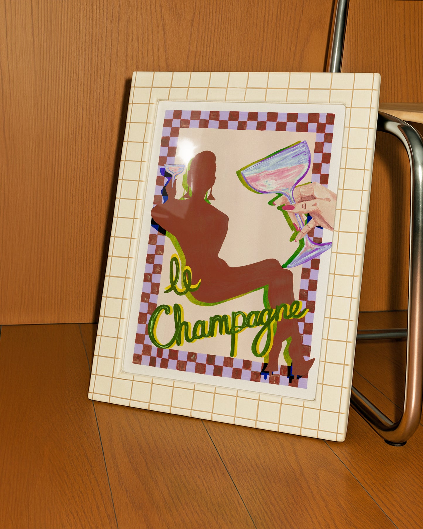 Framed artwork with a silhouette of a person holding a glass of champagne and the text 'le Champagne' on a checkered background.