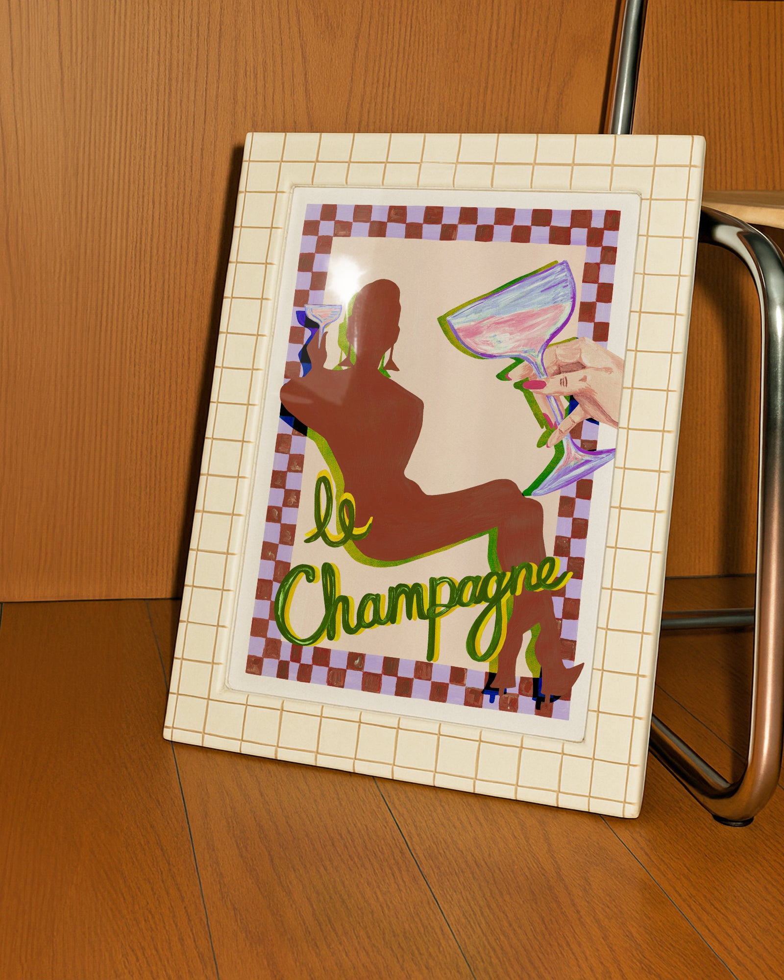 Framed artwork with a silhouette of a person holding a glass of champagne and the text 'le Champagne' on a checkered background.