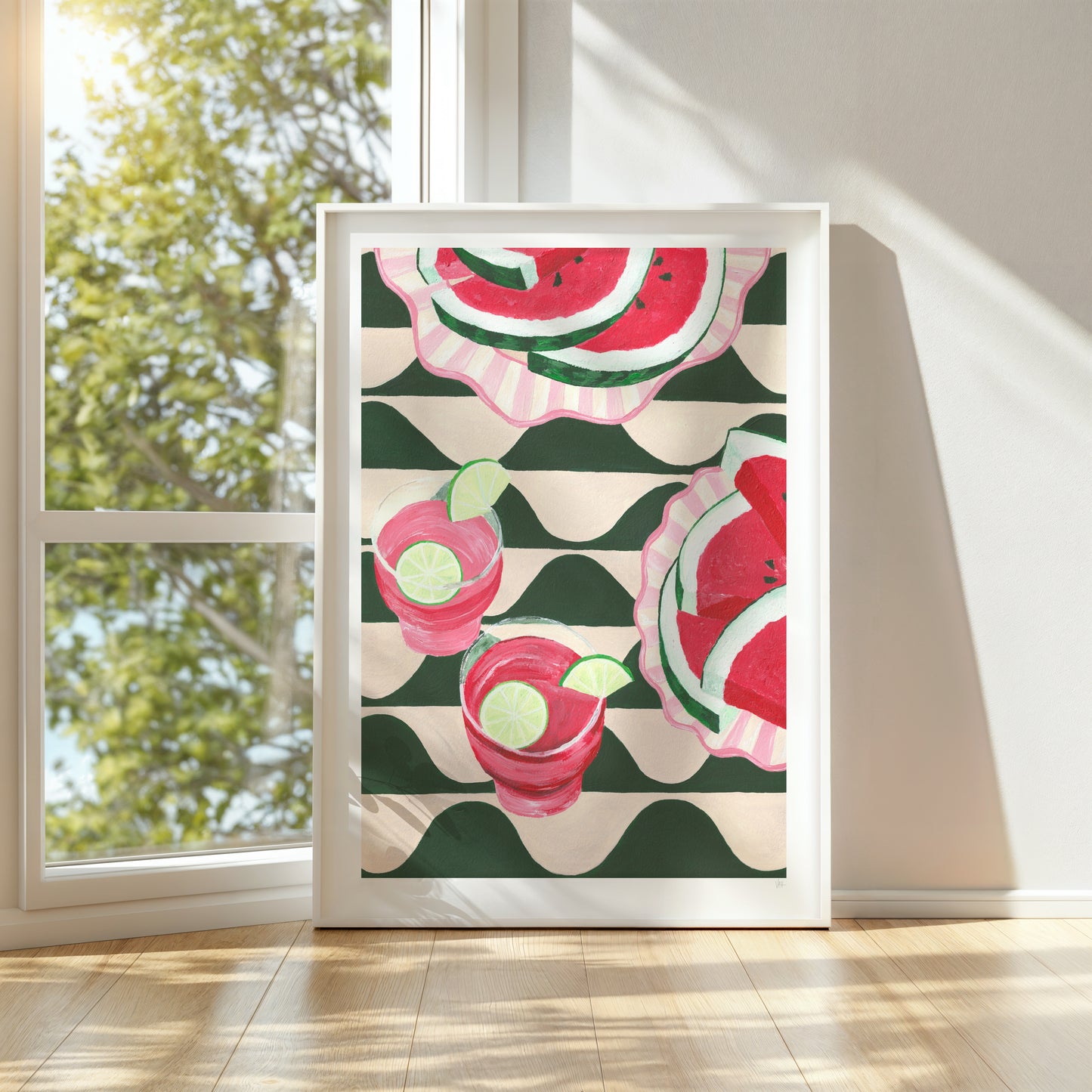 Framed artwork with watermelon pattern on a wall near a window