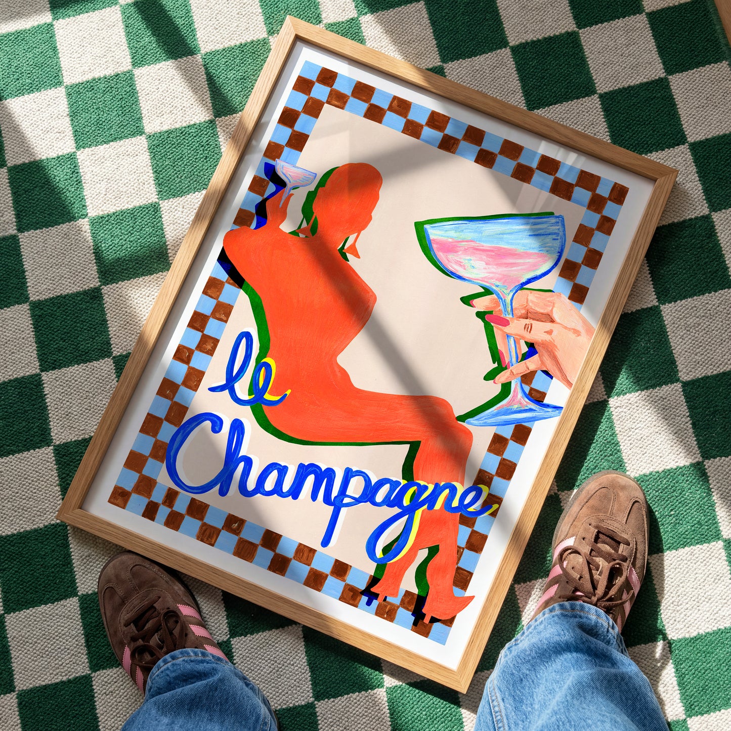 Framed artwork of a woman holding a glass with 'le Champagne' text on a checkered floor.
