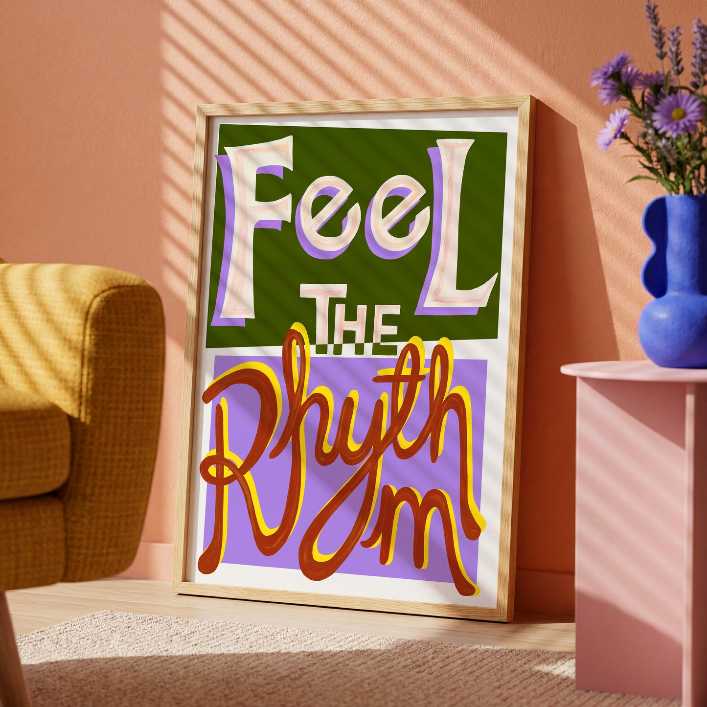 Framed artwork with 'Feel The Rhythm' text in a room with a chair and vase.