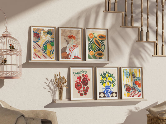 Set of framed artworks on a wall with a decorative birdcage and staircase in the background.
