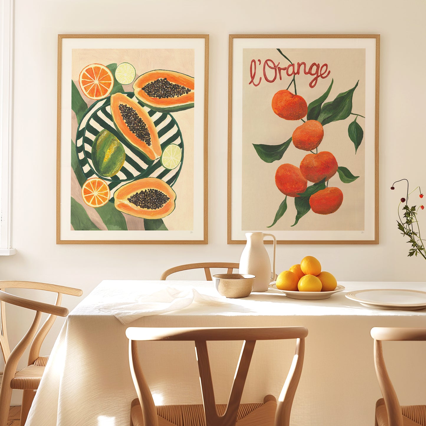 Dining room with fruit-themed wall art and a table set with fruits.