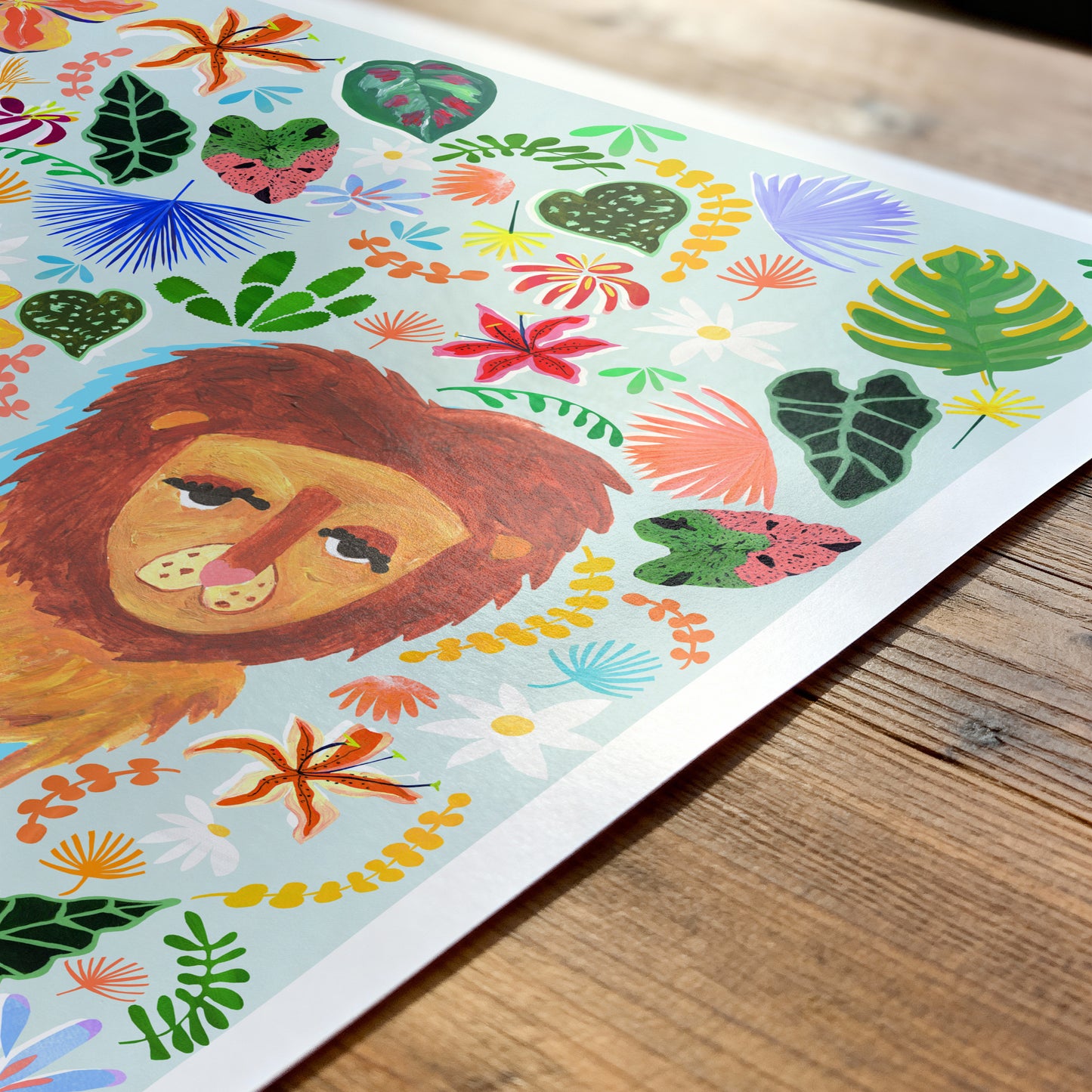Colorful illustration of a lion surrounded by flowers and leaves on a wooden surface