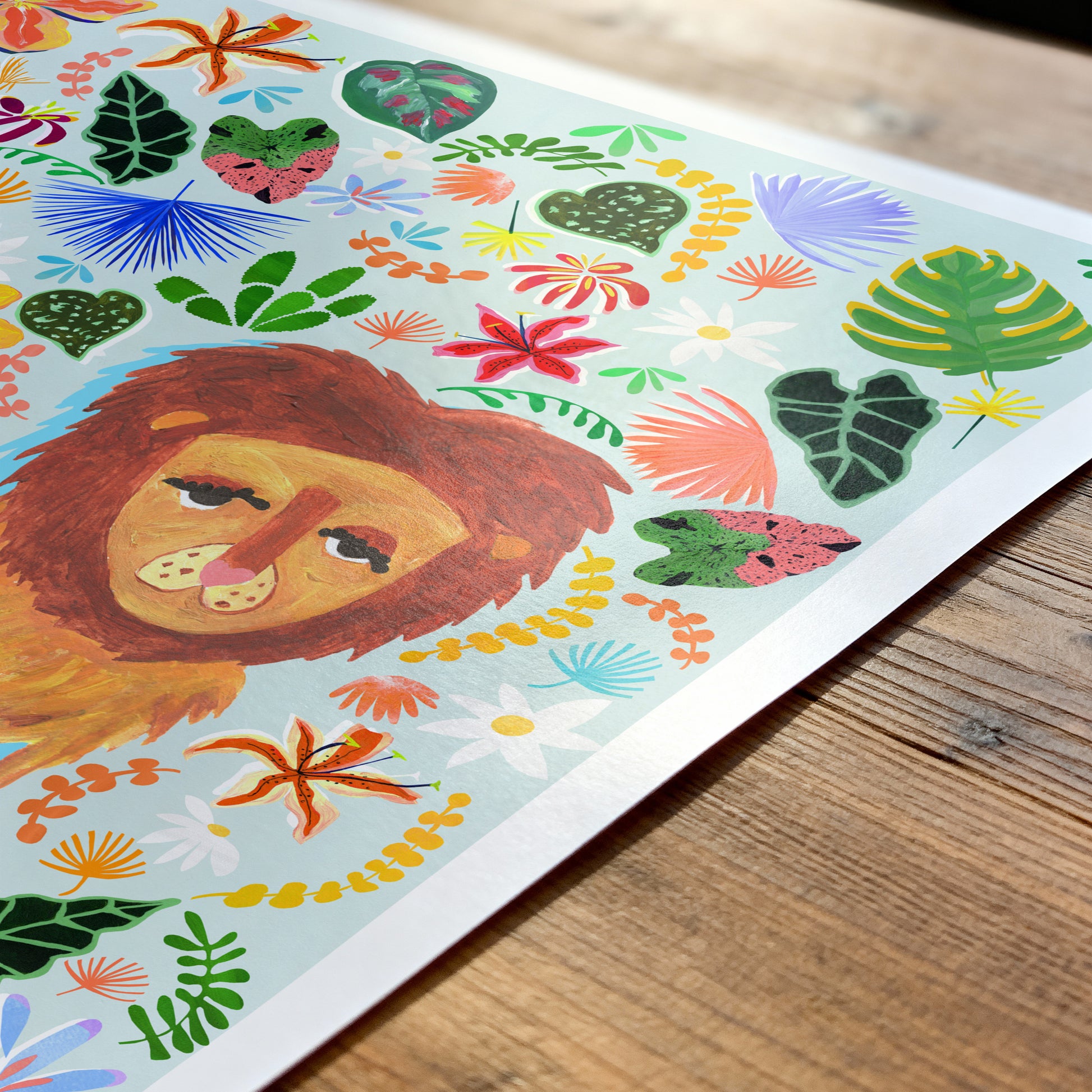 Colorful illustration of a lion surrounded by flowers and leaves on a wooden surface