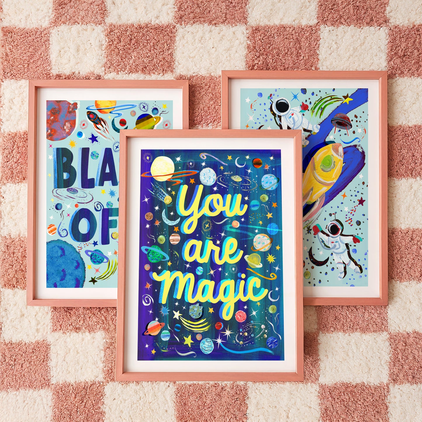 Three framed artworks on a checkered wall, with 'You are magic' being the central piece.