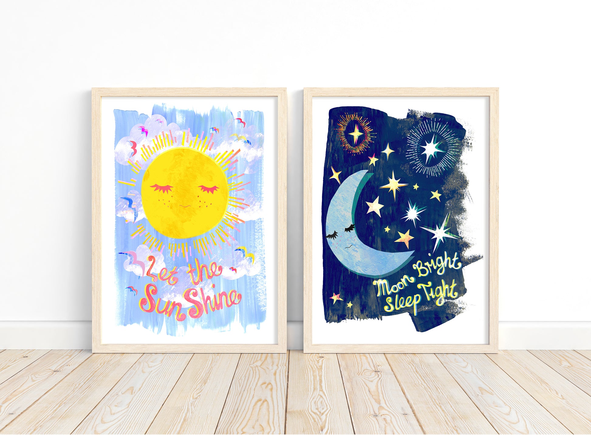 Two framed artworks depicting a sun and moon with text on a white wall.