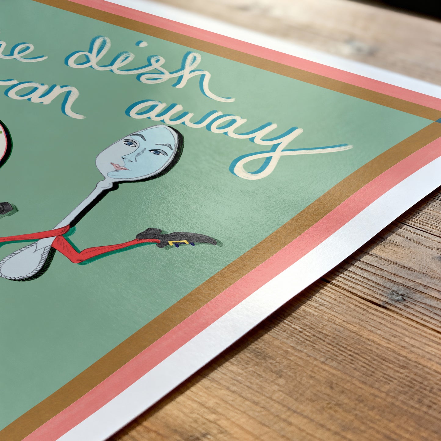 Card with a spoon character and text on a wooden surface