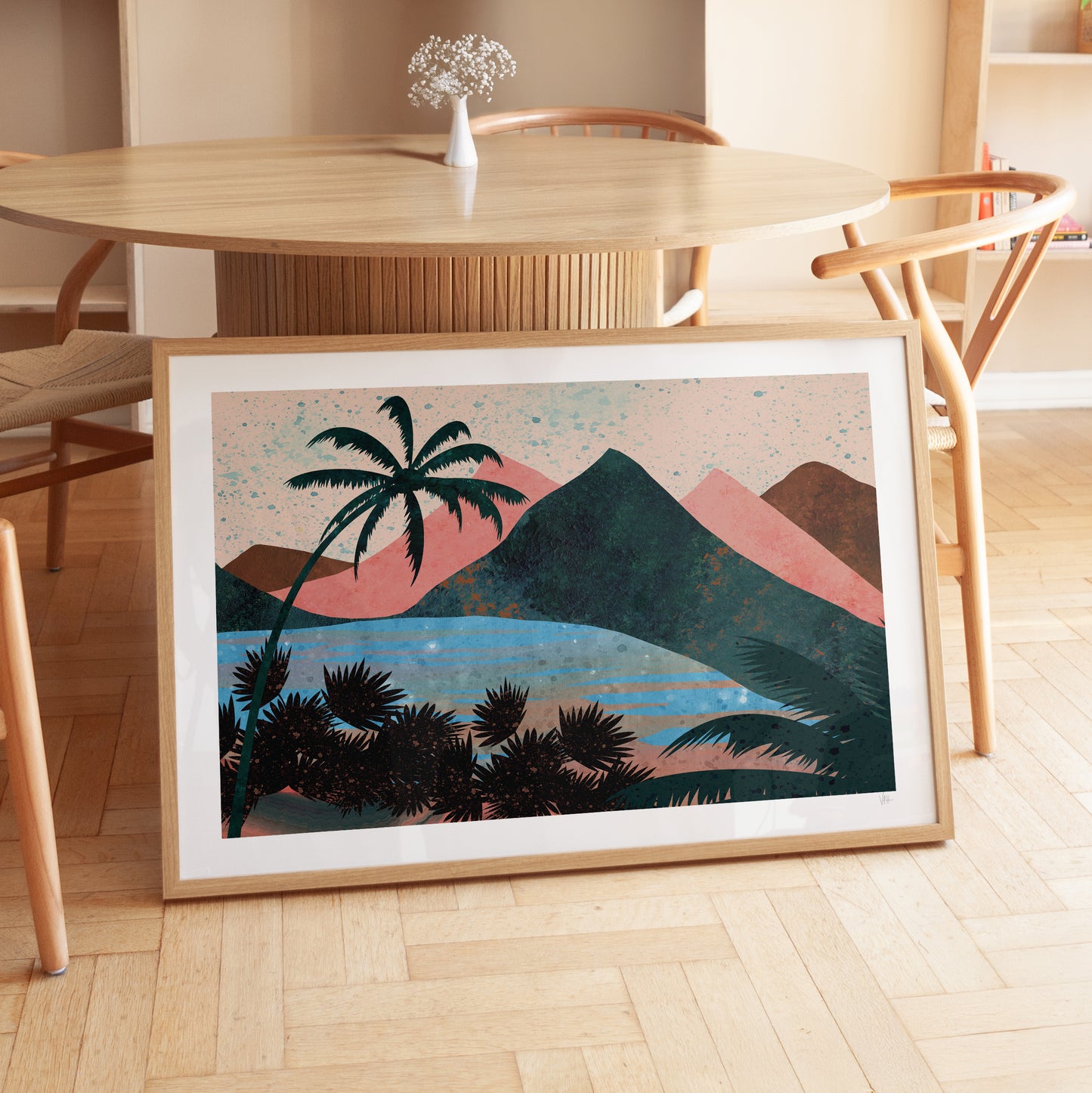 Framed artwork of a tropical landscape with palm trees and mountains on a wooden floor.