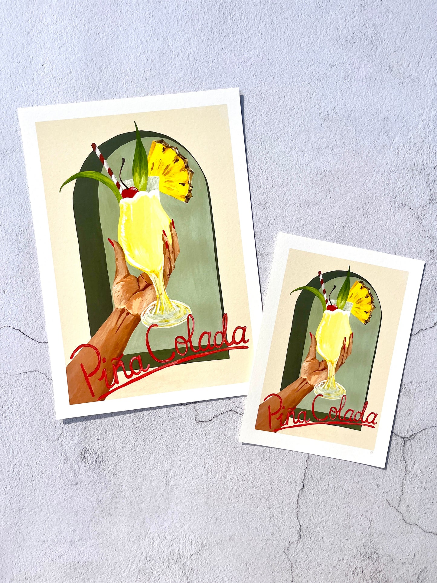 Two art prints featuring a Pina Colada illustration on a textured gray background