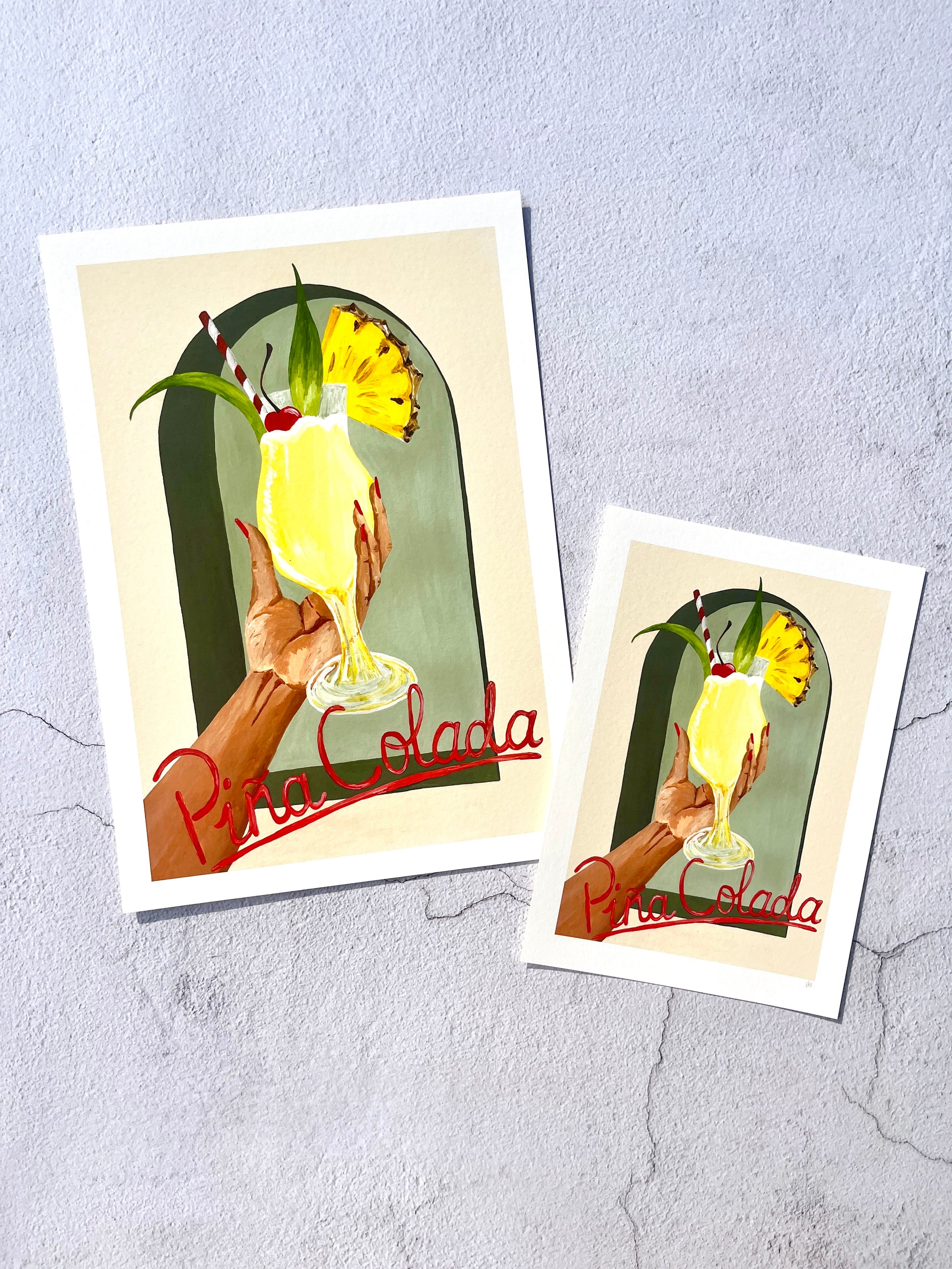 Two art prints featuring a Pina Colada illustration on a textured gray background