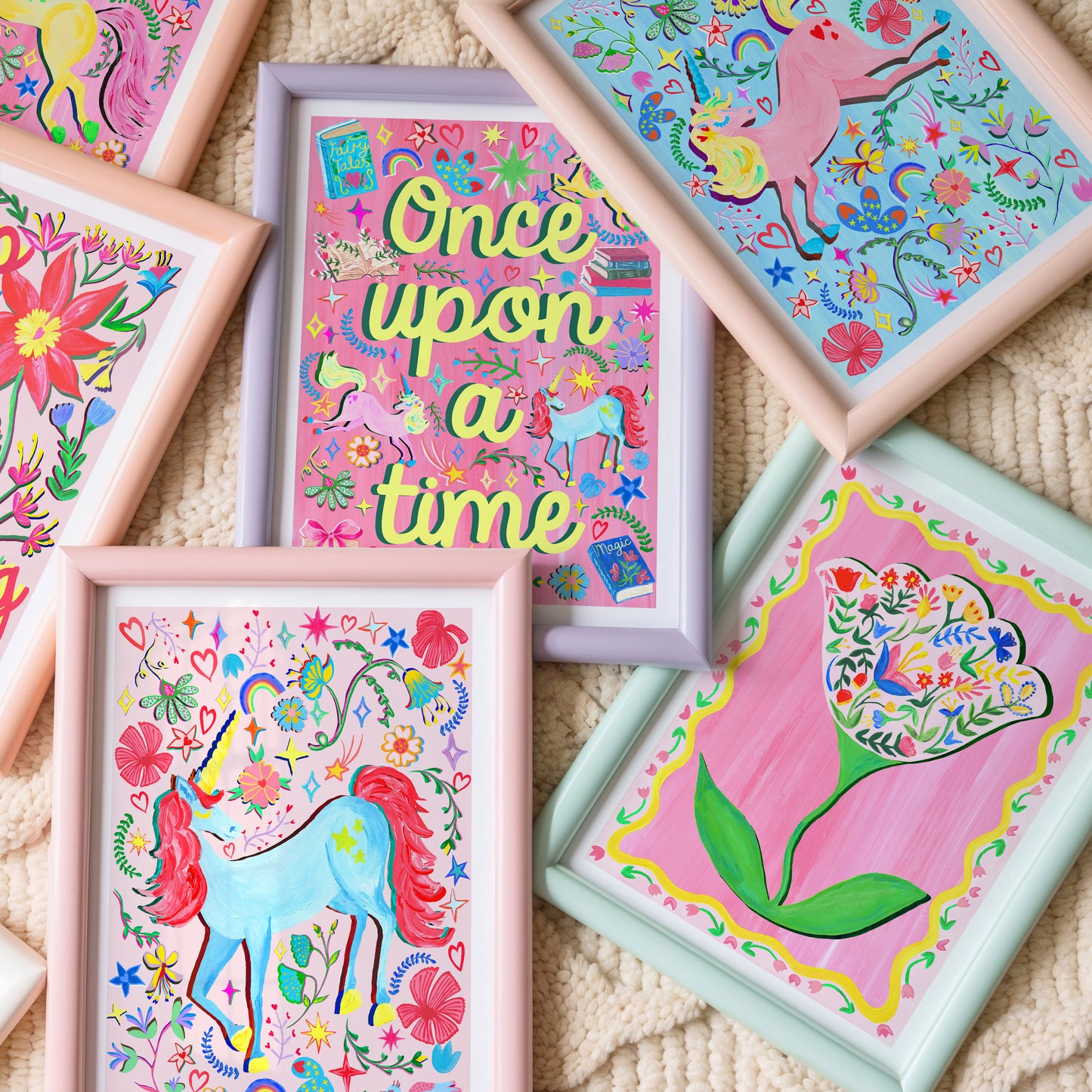 Colorful children's artwork featuring unicorns and floral designs on a textured surface.