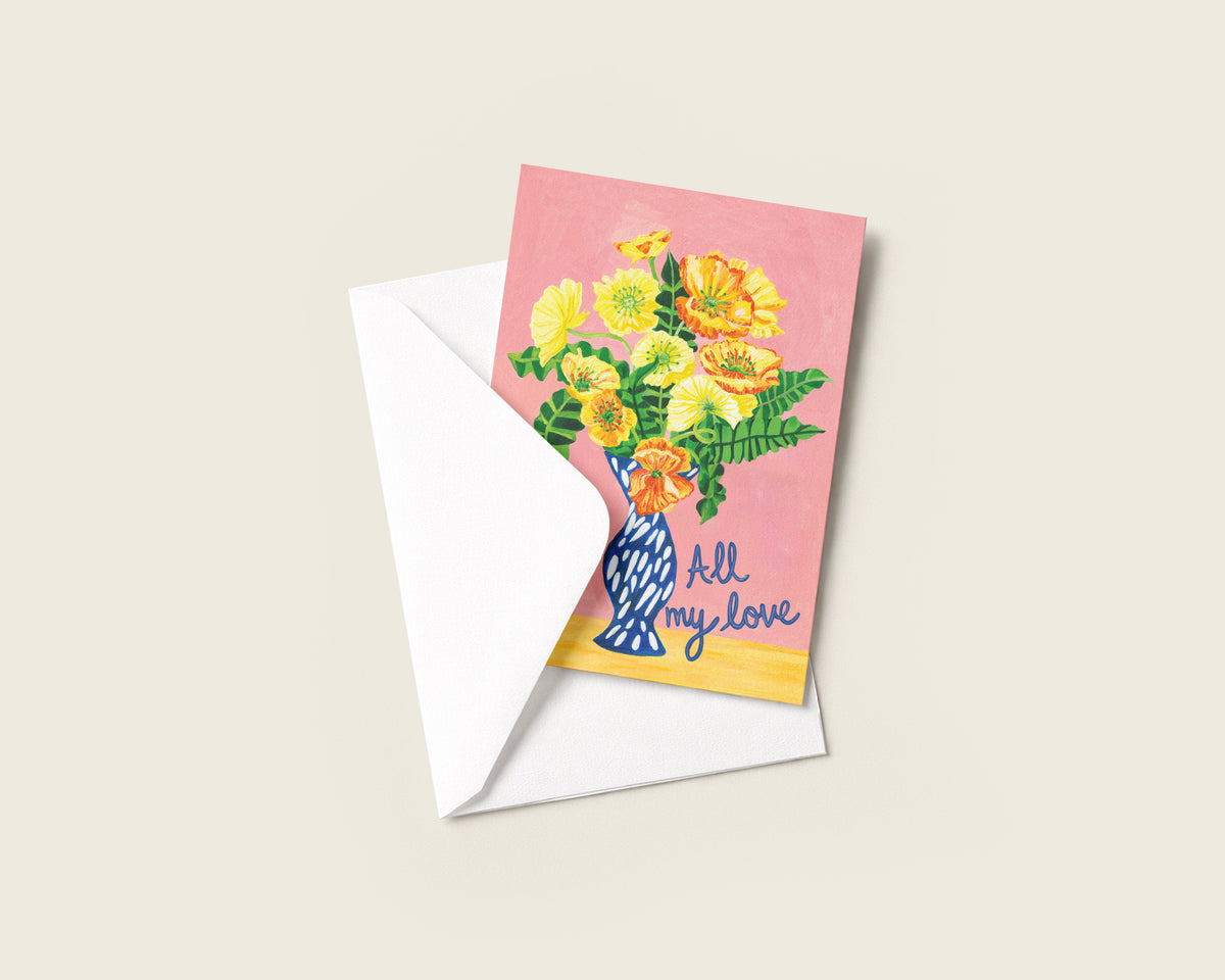 A greeting card with a pink background and an illustration of yellow flowers in a blue vase, partially tucked into a white envelope. The card reads 'All my love' in blue script.