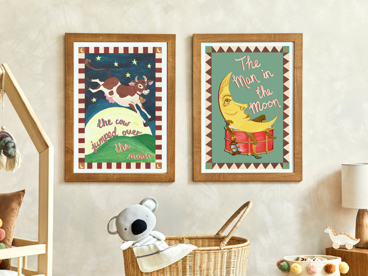 Two framed illustrations on a wall with a teddy bear and basket in the foreground.