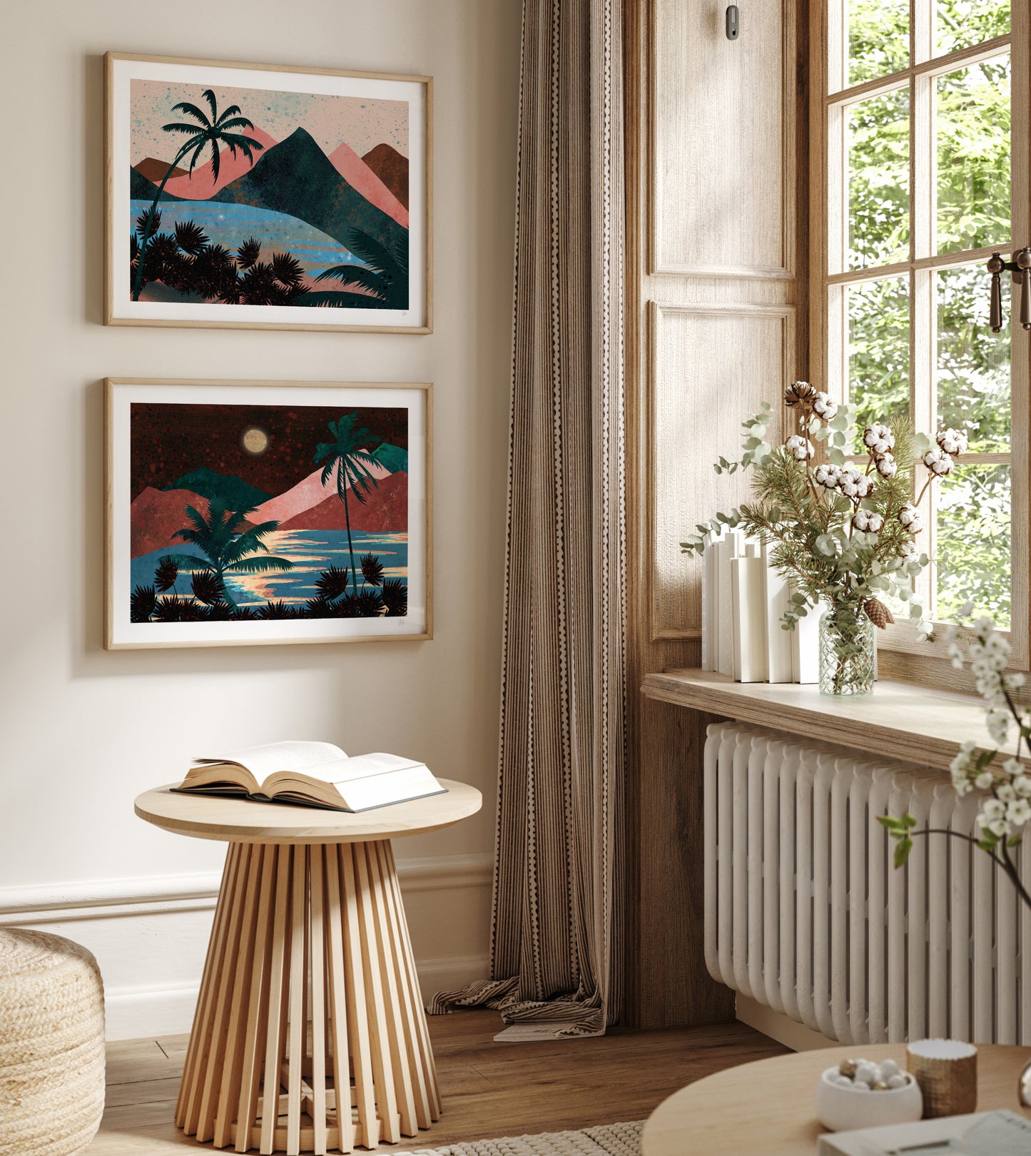 Living room with wooden side table, open book, and wall art depicting tropical landscapes.