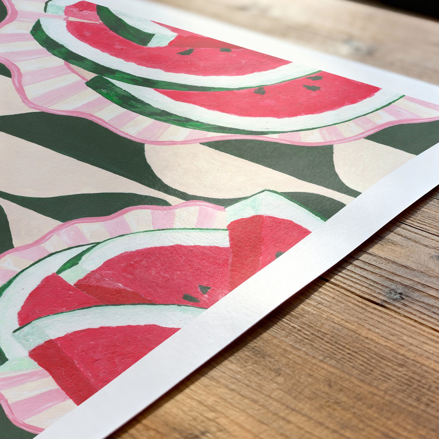Sheet of paper with watermelon pattern on a wooden surface