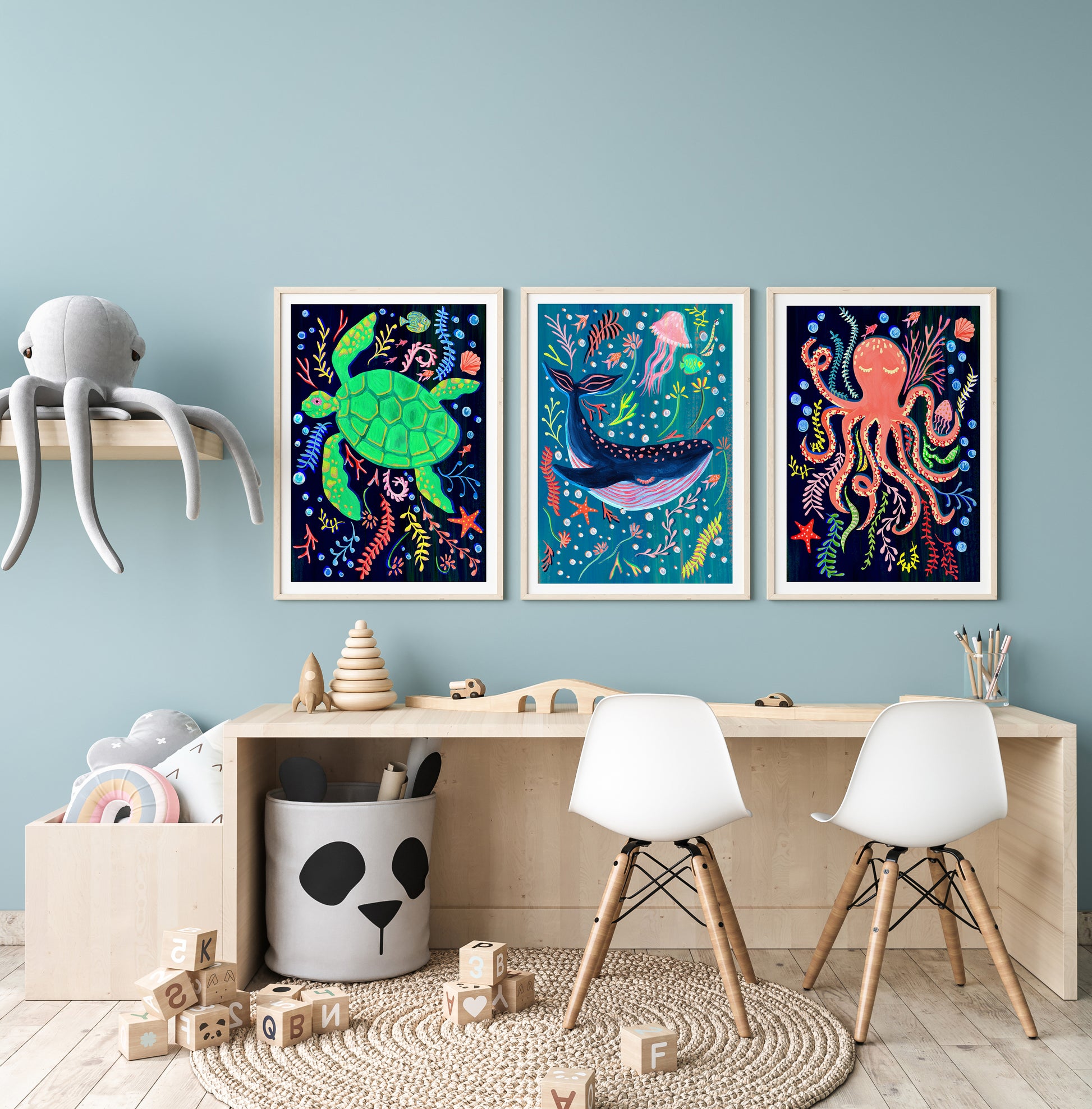 Children's room with colorful wall art, toys, and furniture against a light blue wall.