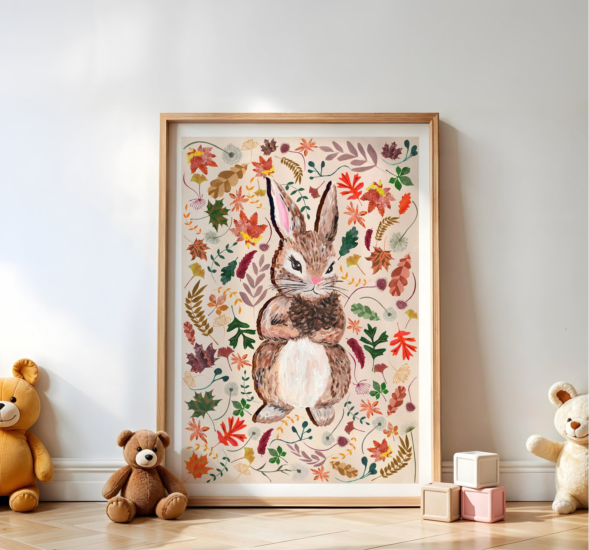 Framed artwork of a rabbit surrounded by flowers on a wall with teddy bears and blocks on the floor.