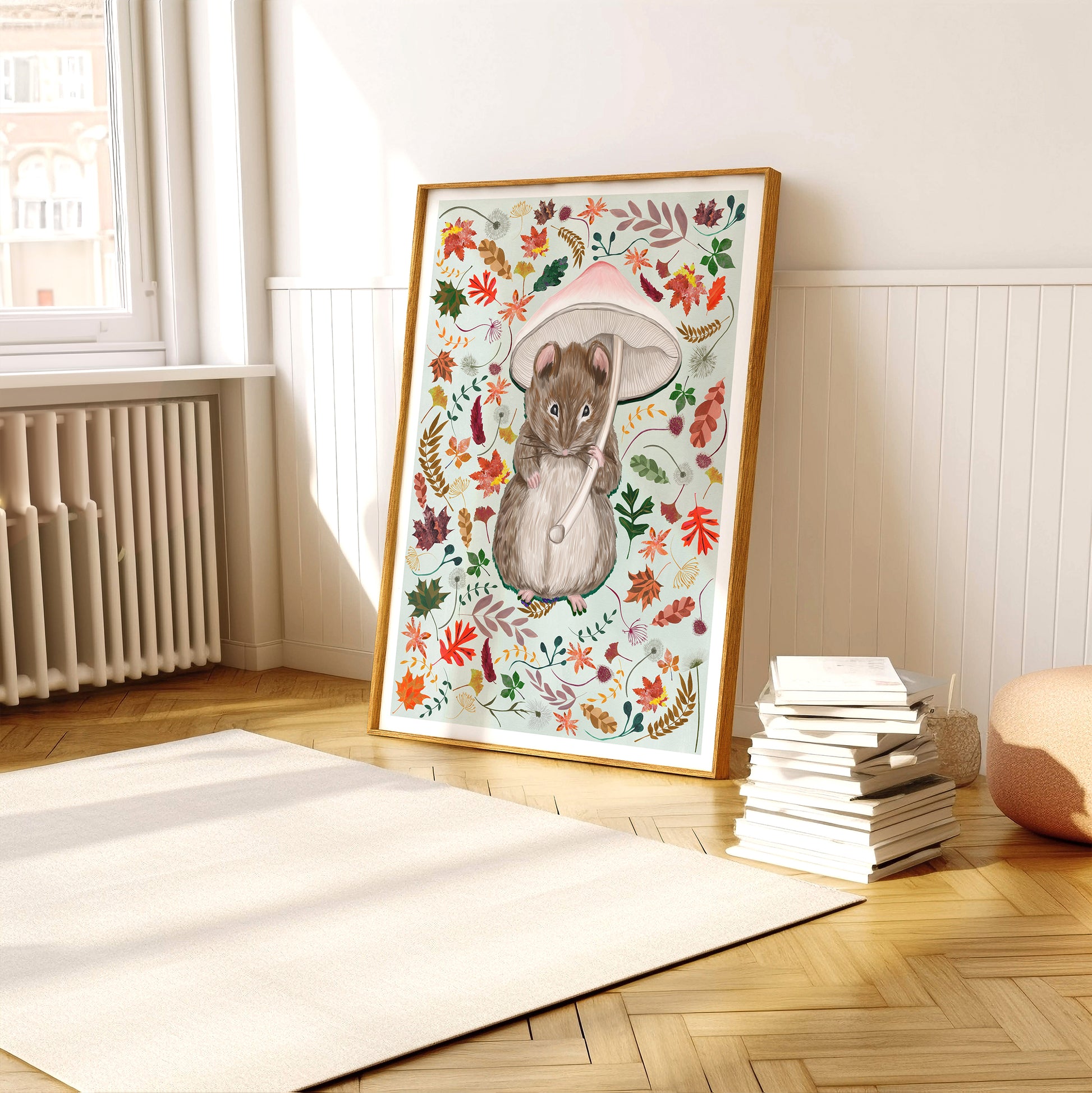Framed artwork of a mouse with autumn leaves on a wall in a room.